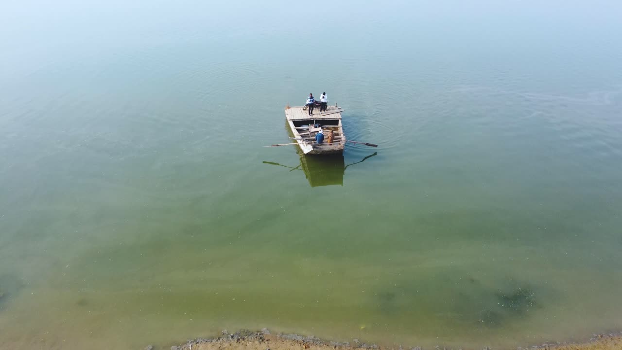 Aerial Drone shot of people travelling in traditional wood boat in blue Chambal River in Morena Dholpur of Madhya Pradesh Rajasthan in India