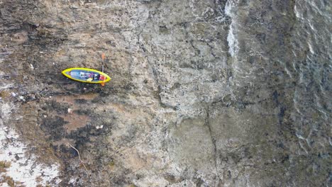 Kayak-and-paddle-on-shore,-waves-washing-on-rocky-beach,-Dugi-Otok,-Croatia