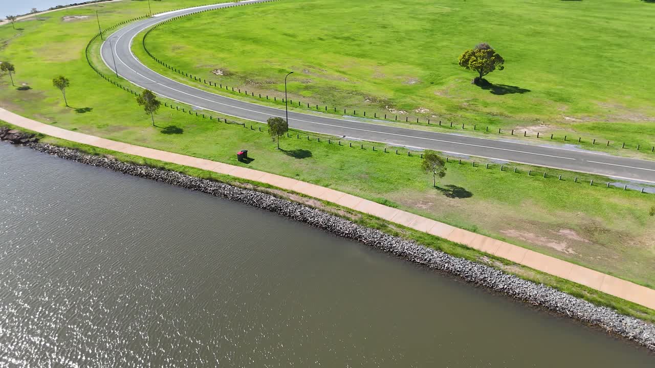 Aerial view of a river, road, and green field