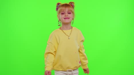 cheerful funny little teen girl kid dancing at camera filming video using phone on chroma key wall