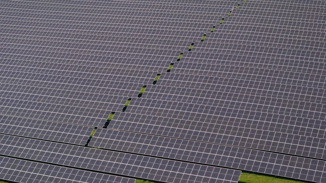 독일의 초록색 언덕에 있는 여러 개의 태양광 패널을 가진 거대한 태양광 발전소 위를 날아갑니다. 재생 가능 에너지, 항공 영상