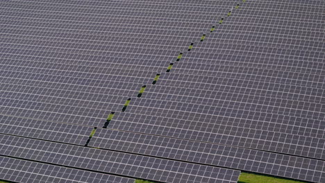 Fliegen-Sie-über-Ein-Riesiges-Solarkraftwerk-Mit-Mehreren-Solarpaneelen-Auf-Einem-Grünen-Hügel-In-Deutschland,-Erneuerbare-Energien,-Luftaufnahmen