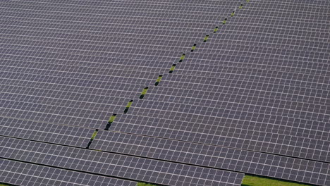 volar sobre una enorme planta de energía solar con múltiples paneles solares en una colina verde en alemania, energía renovable, imágenes aéreas