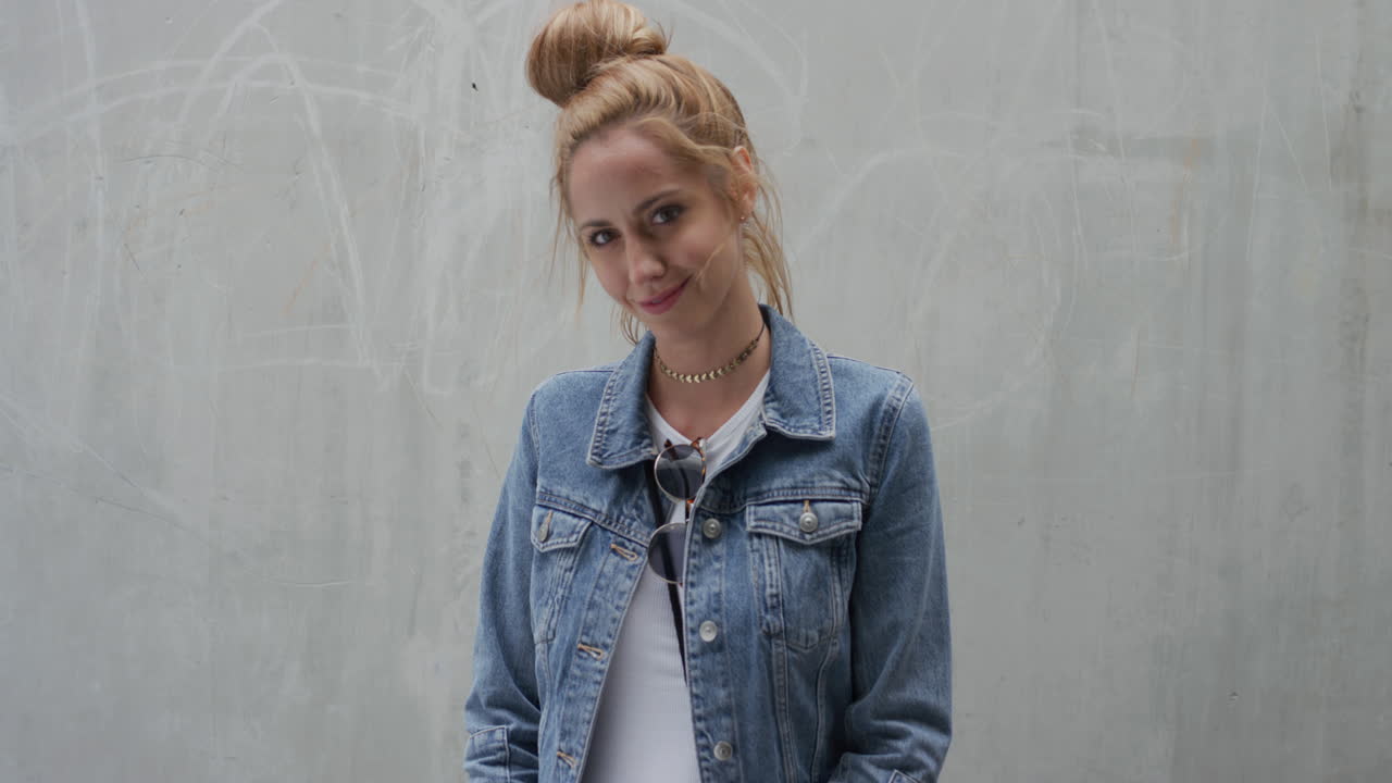 ritratto bella giovane donna sorridente che corre con la mano attraverso i capelli indossa elegante denim moda godendo di uno stile di vita urbano indipendente serie di persone reali