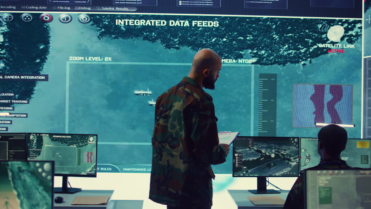 oficial del ejército examinando datos de satélite en tiempo real en una gran pantalla en una base militar