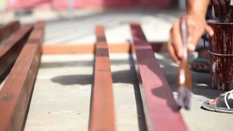 a carpenter is painting wood for building