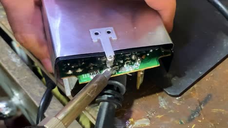 Technician open device cover using soldering machine carefully