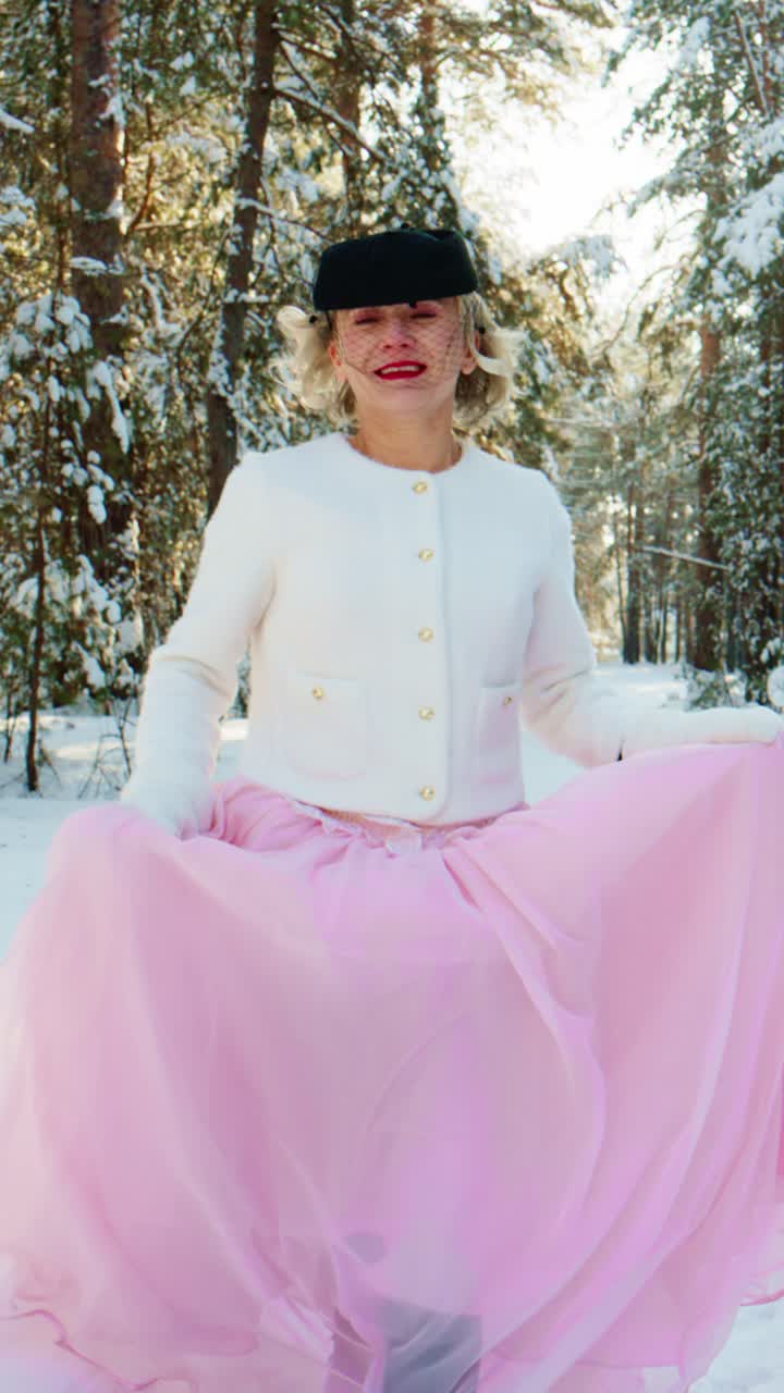 Donna gioiosa in abito elegante che posa in un paesaggio invernale incantato