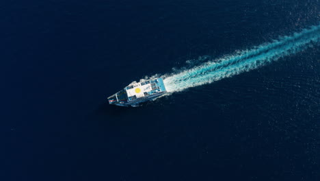 greek ferry with backwash on surface of calm blue sea in crete island, greece