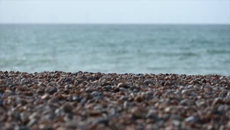 tilt up: pebbles on a brighton beach, sussex, united kingdom, english channel on the horizon