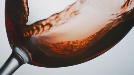 red-wine-flowing-into-the-bottom-of-a-glass,-closeup,-highspeed