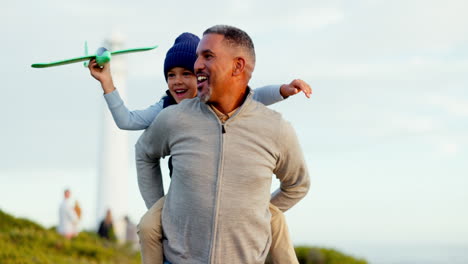 man, child and beach with toy plane