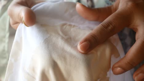 woman's hands showing a stain on white fabric