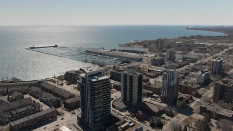 Vista-Desde-Un-Dron-De-Edificios-De-Apartamentos-Y-Pequeñas-Tiendas-A-Orillas-Del-Lago-Ontario-En-Mississauga