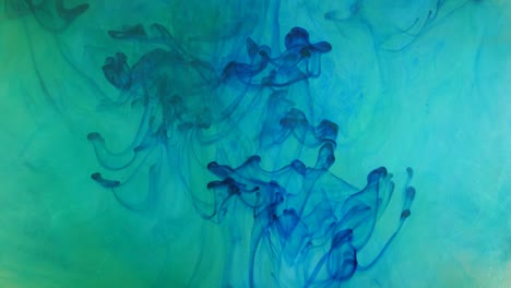 propagación de pintura azul, verde y blanca en un espacio líquido.