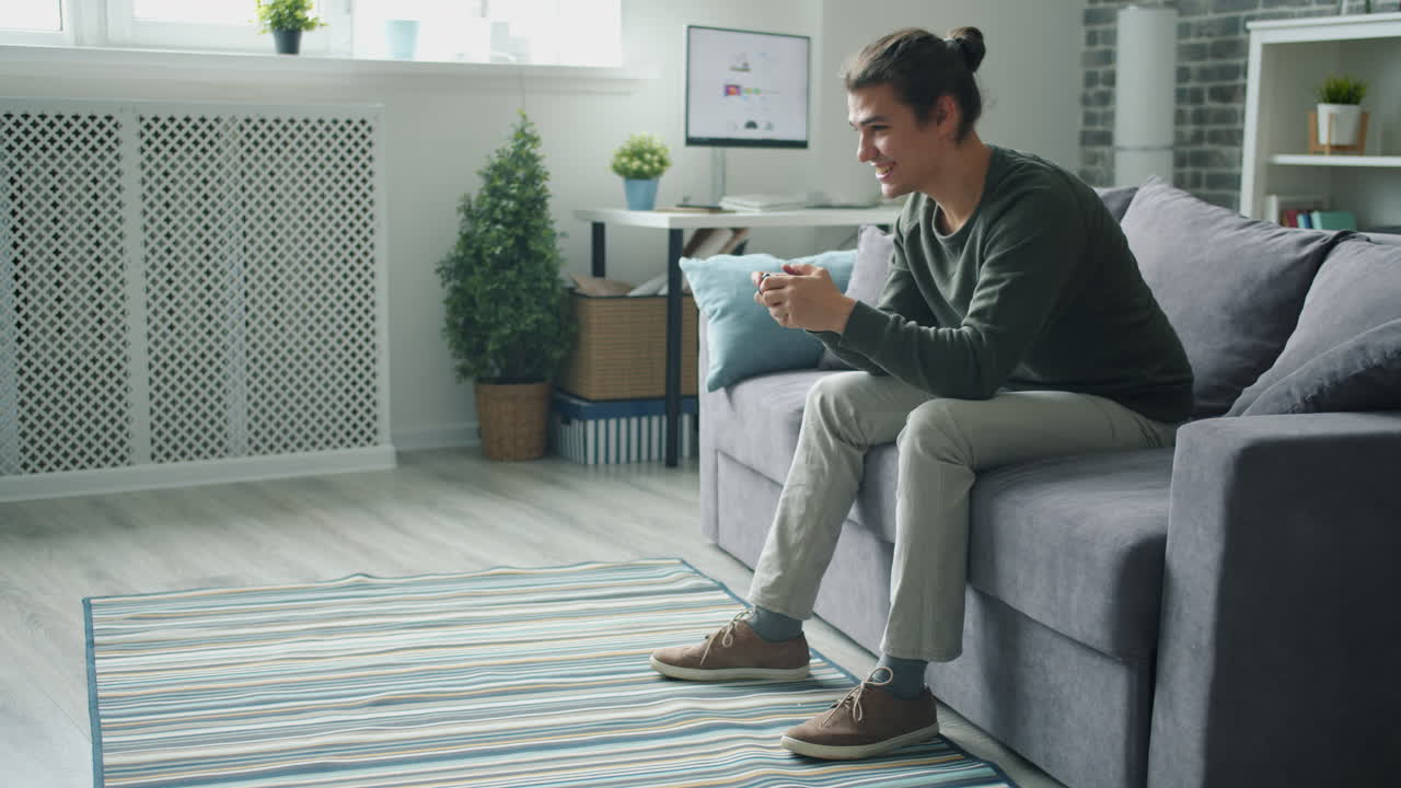 hombre jugando videojuegos en un sofá