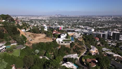 aerial over hollywood west luxury neighborhood facing sunset blvd and downtown los angeles on clear blue day