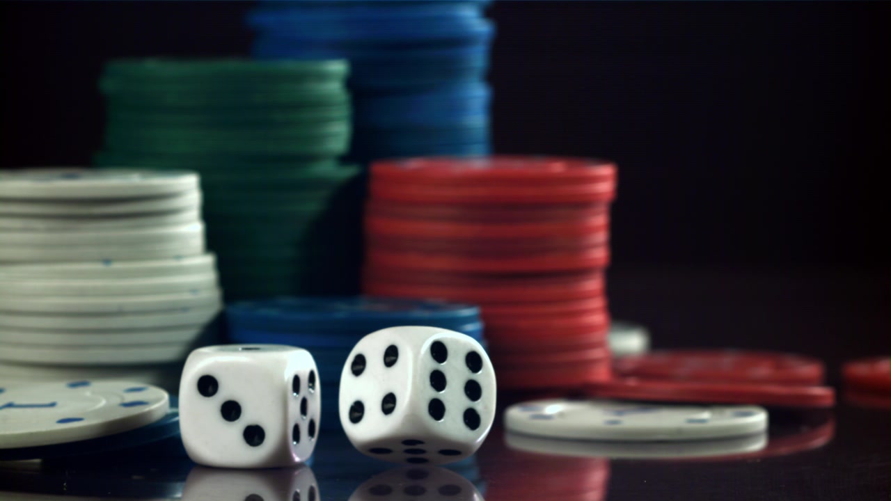 Dadi che rotolano al rallentatore su una superficie riflettente con fiches da poker