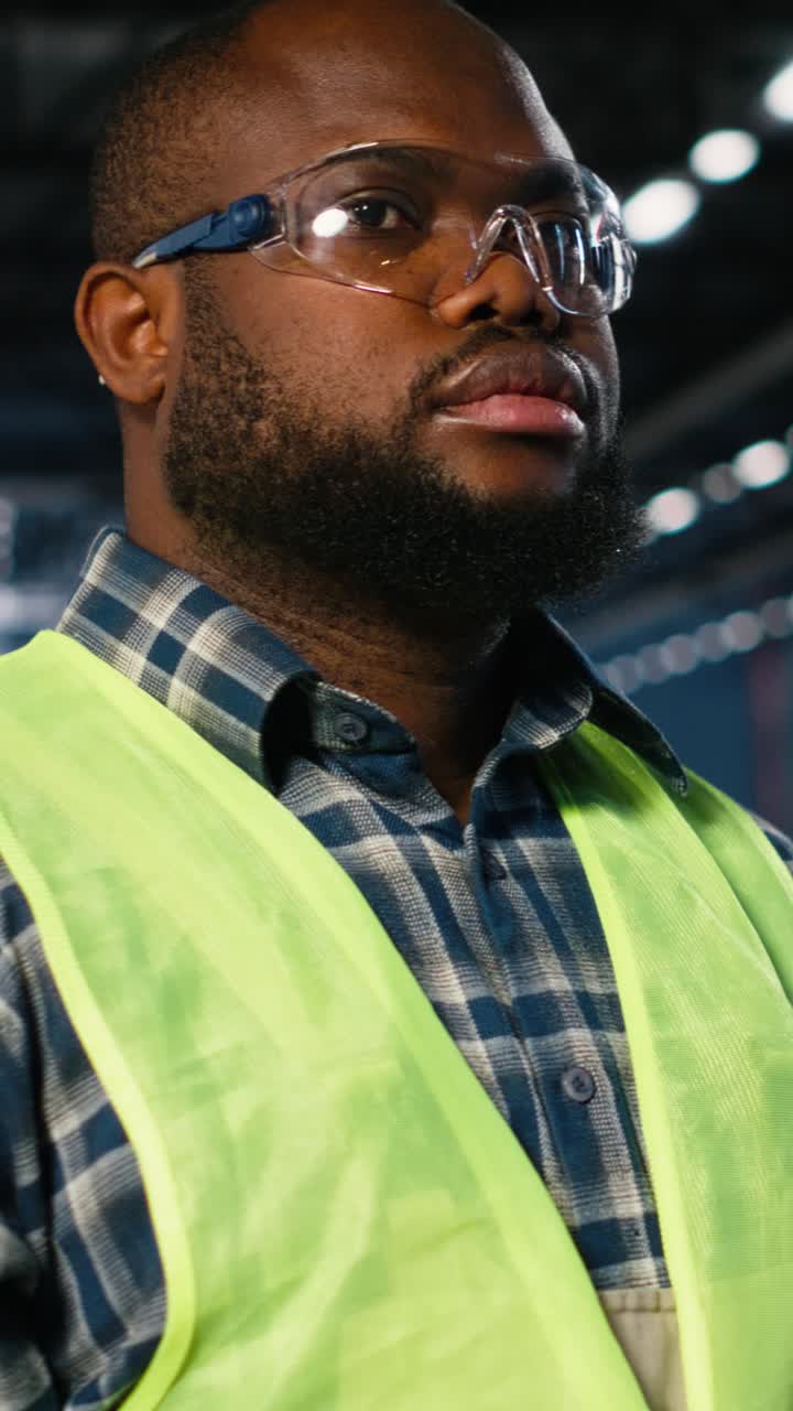 Vertical Video Engineer in safety glasses uses tools in a fabrication workshop