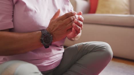 mujer de dos razas practicando yoga y meditando en la sala de estar