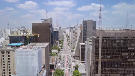 avenida paulista, the business heart of sao paulo and brazil in a busy summer day- ascending aerial drone flying shot of streets of a famous city in south america