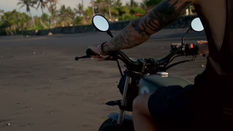 motocicleta en una playa de arena negra al atardecer