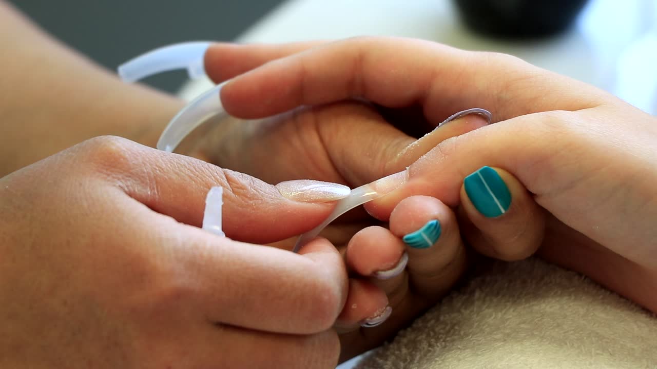 A girl has nails treatment to have false nails