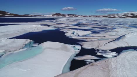 Aerial-over-a-high-mountain-lake-with-large-melting-ice-sheets-and-icebergs-in-Iceland