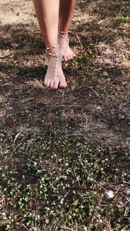 barefoot woman with pearl anklets in nature