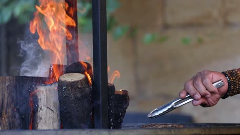 cocinar carne en una parrilla de leña