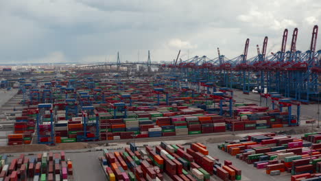 Aerial-view-of-many-automated-cranes-sorting-and-placing-cargo-containers-in-large-shipping-port-in-Hamburg,-Germany