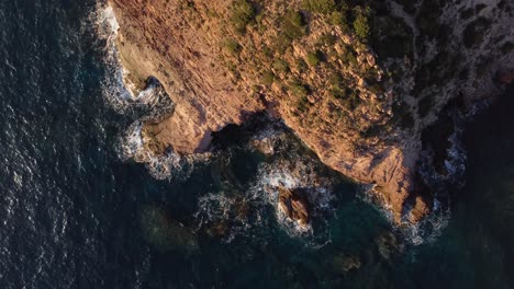 Top-down-aerial-view-of-steep-rugged-remote-rocky-cliff-coast,-Mediterranean-sea