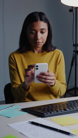woman working on phone at desk