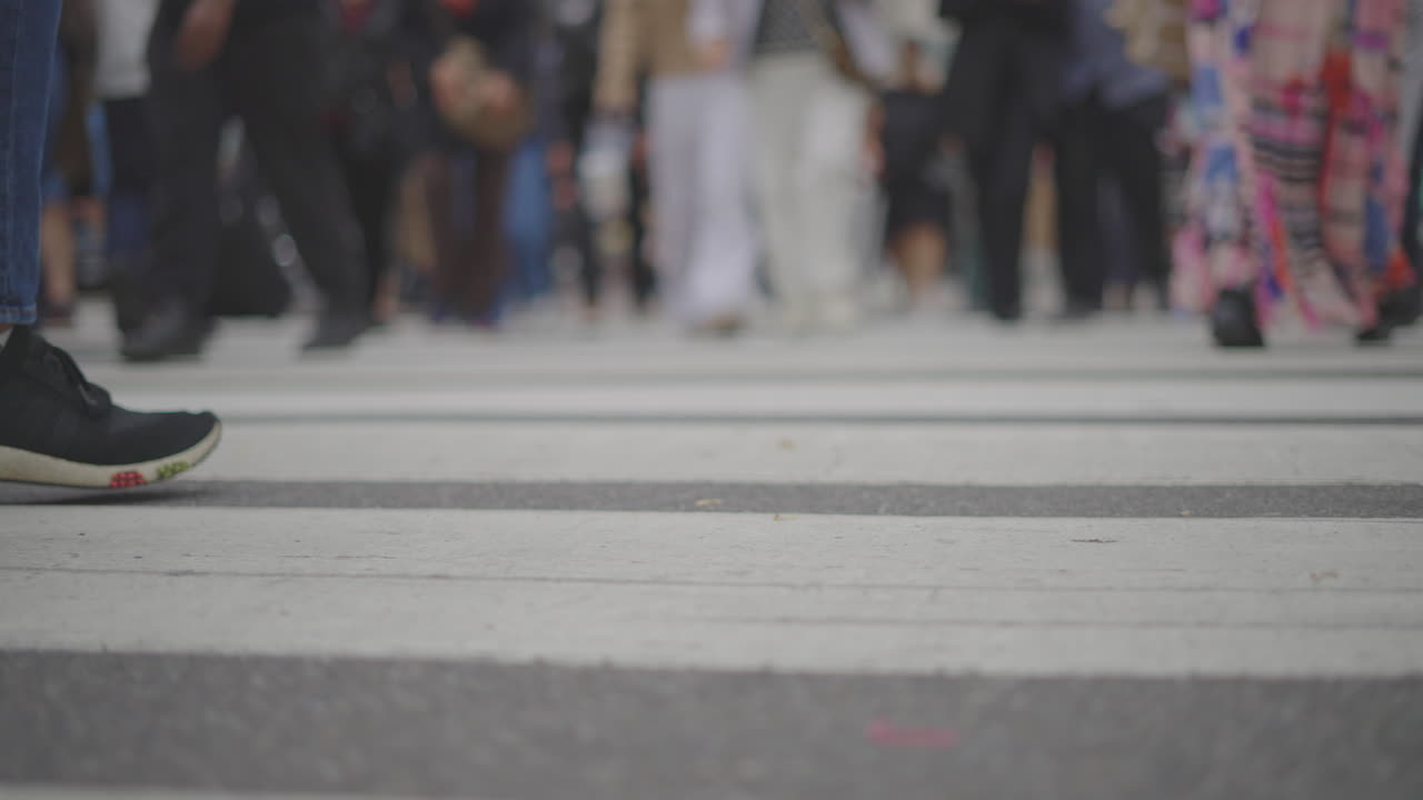Pedoni che attraversano un passaggio pedonale in città