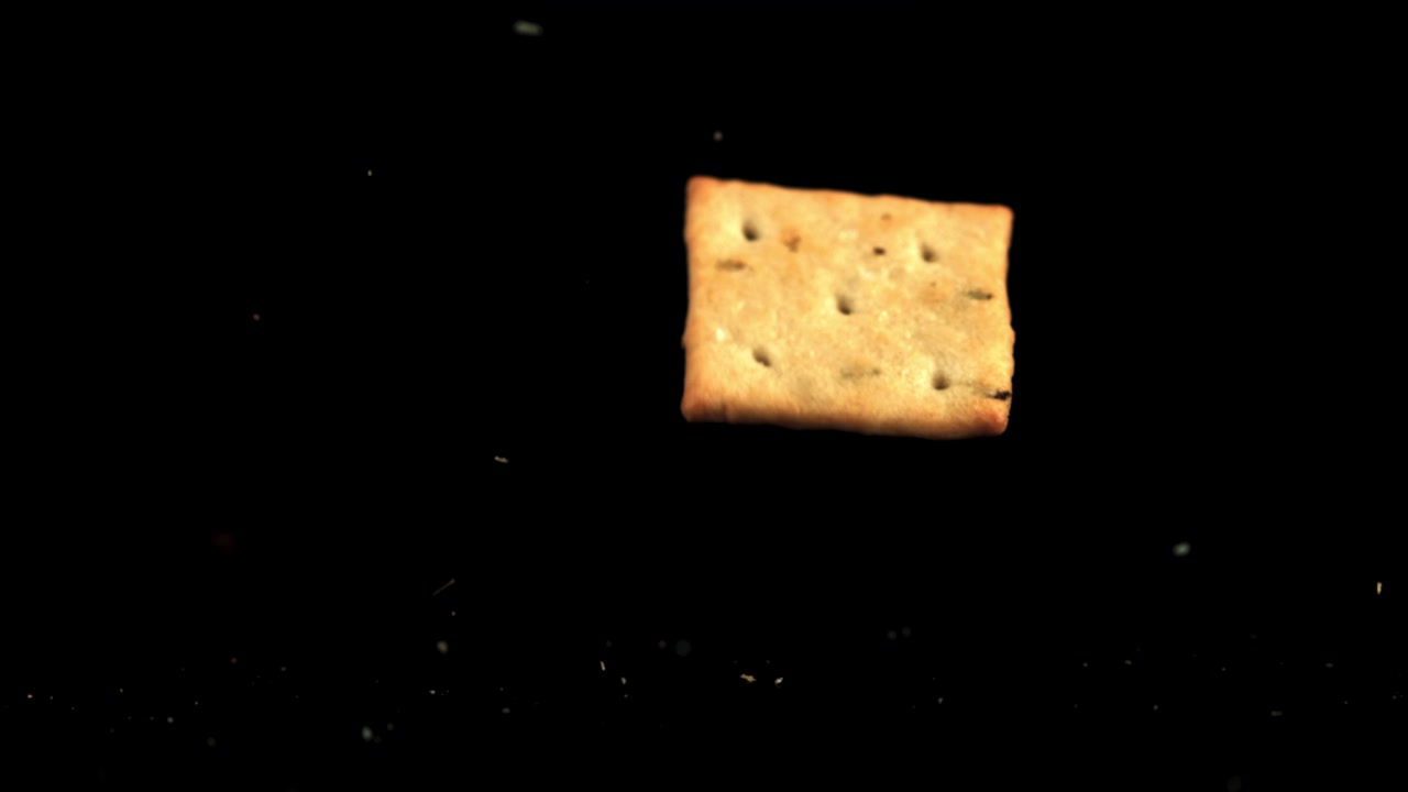 Cracker Falling in Slow Motion Against Black Background