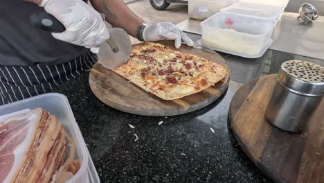 el chef adornando y cortando la pizza de manera eficiente.