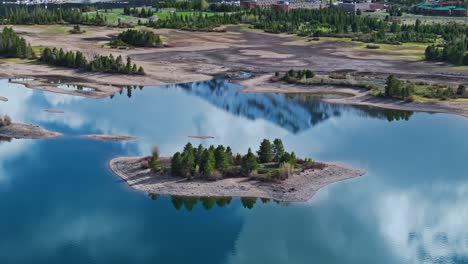 Sandy-island-with-evergreen-trees-and-cloudy-sky-and-Frisco-Colorado-snow-capped-peaks-in-reflection-of-water-at-Dillon-Reservoir