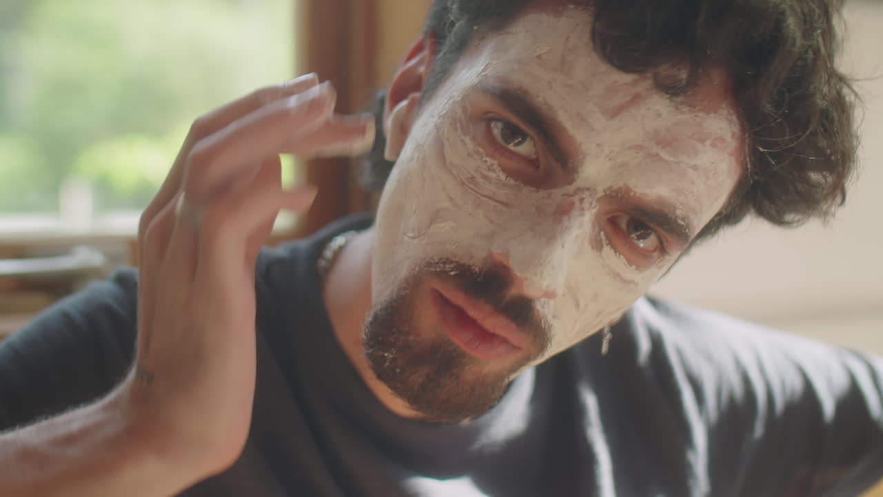 Man Looking at Camera and Applying Face Mask