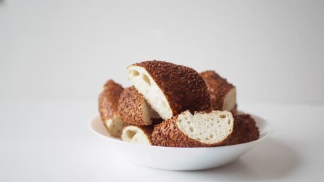 recogiendo a mano rebanadas de pan simit turco de un cuenco