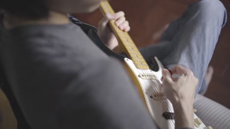 a man playing electric guitar on a bed