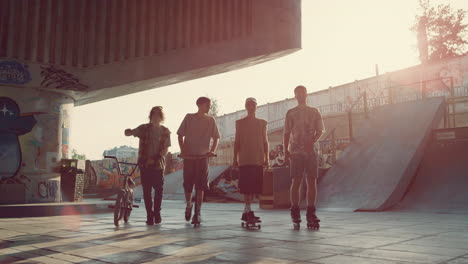 Teens-friends-skateboarder-bmx-rider-roller-skater-and-scooter-rider-walking.