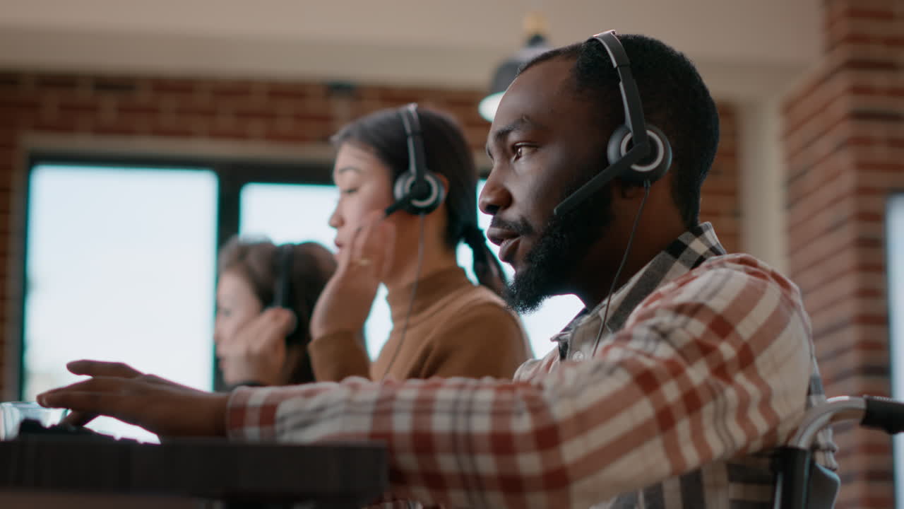 Male worker answering phone call on audio headset at customer service