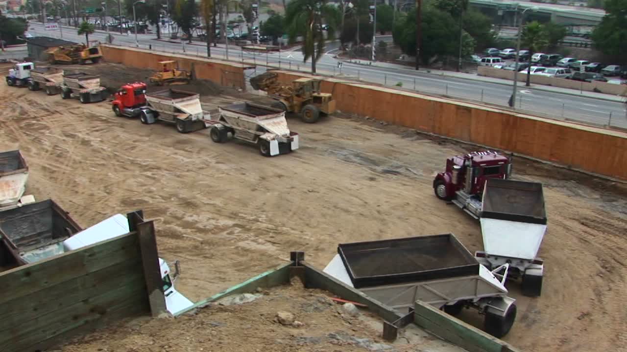 una retroexcavadora vuelca una carga de tierra en el remolque de un semi