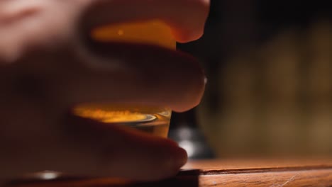 man picking up beer glass while playing chess