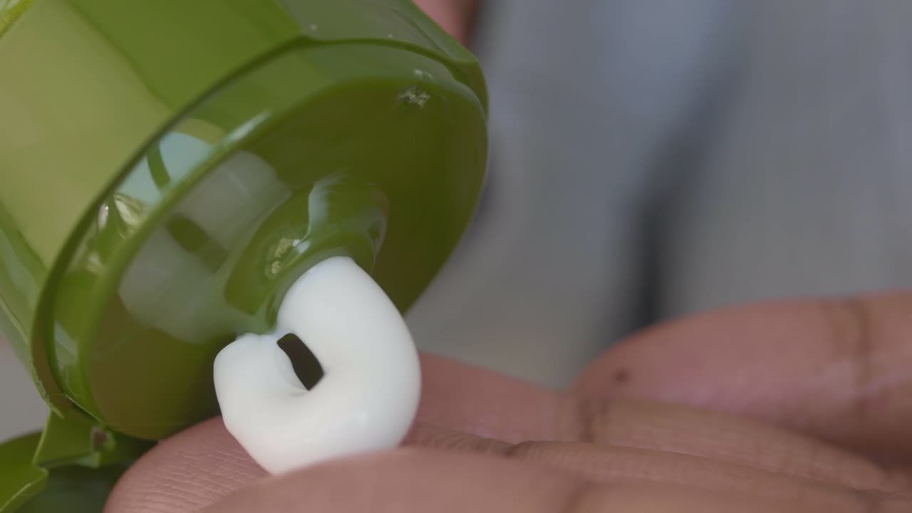 Close up of a person applying lotion to their hand