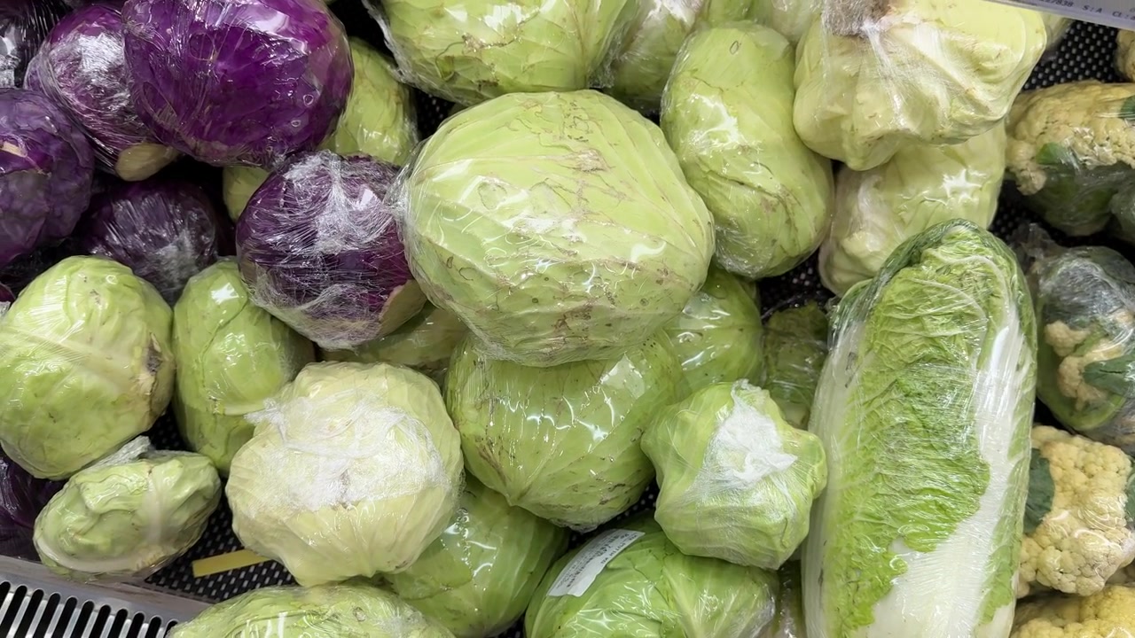 Variety of Fresh Cabbage and Vegetables Wrapped in Plastic