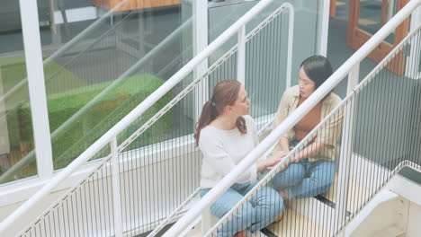 friends, women sitting on stairs at apartment