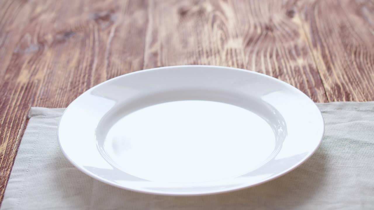 사과 파이 - 은 나무 테이블 위에 탁자, 접시, 사과파이가 나타납니다. 남자의 손은 그것을 설탕 가루로 뿌립니다.