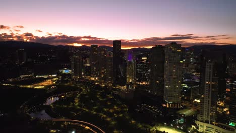 Aerial-view-away-from-silhouette-condos-and-the-La-Mexicana-park-in-Santa-Fe,-Mexico---pull-back,-drone-shot