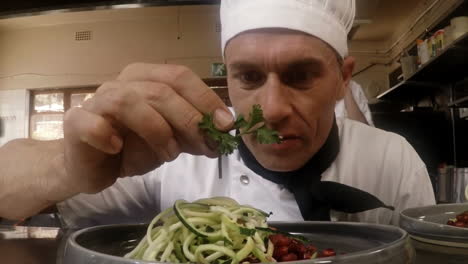 male chef garnishing food